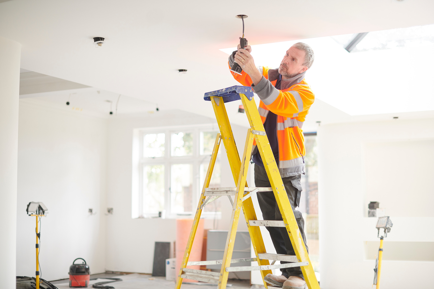 electrician installing downlights